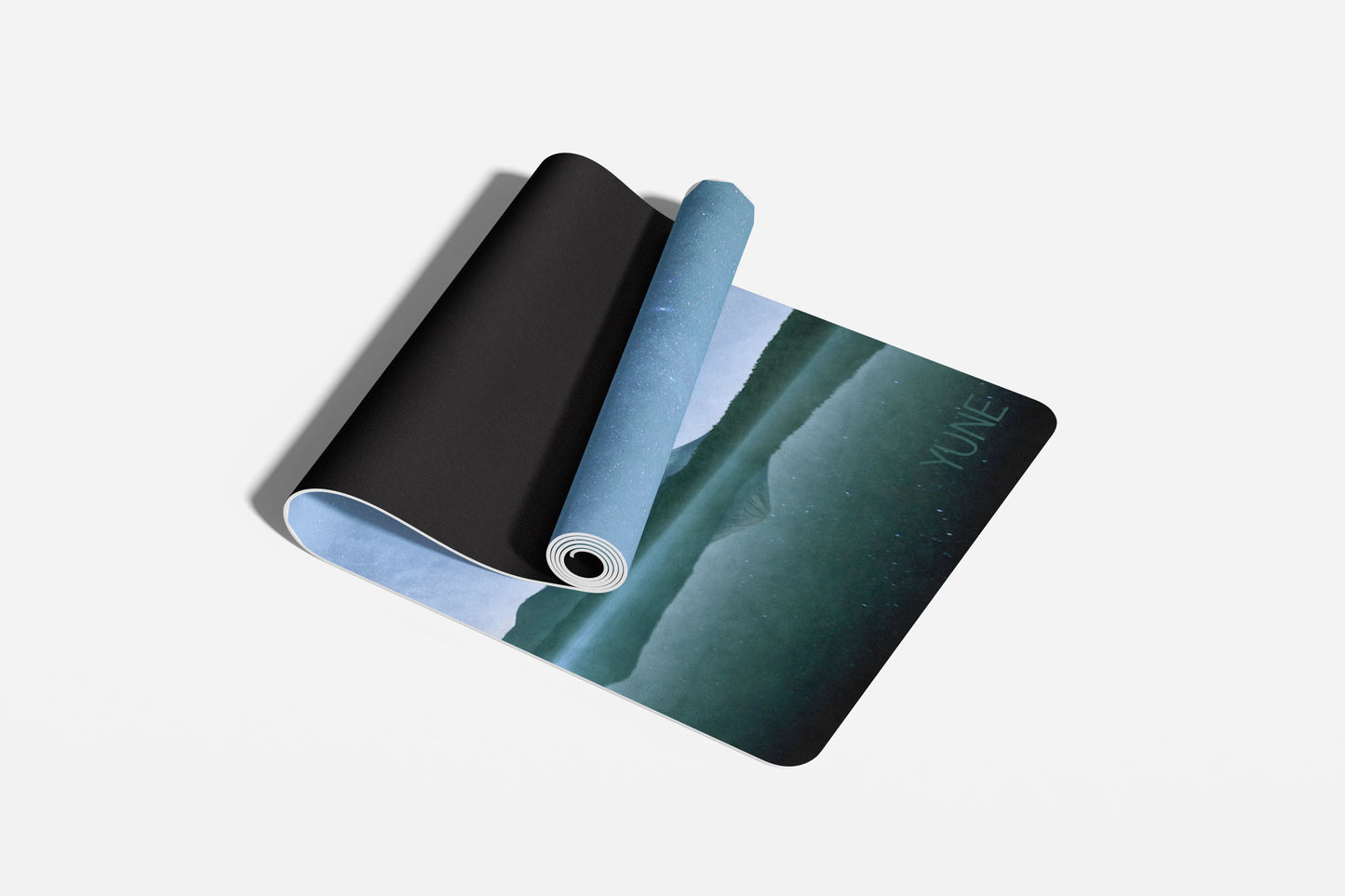 Three yoga mats in black, blue, and green on a light gray background