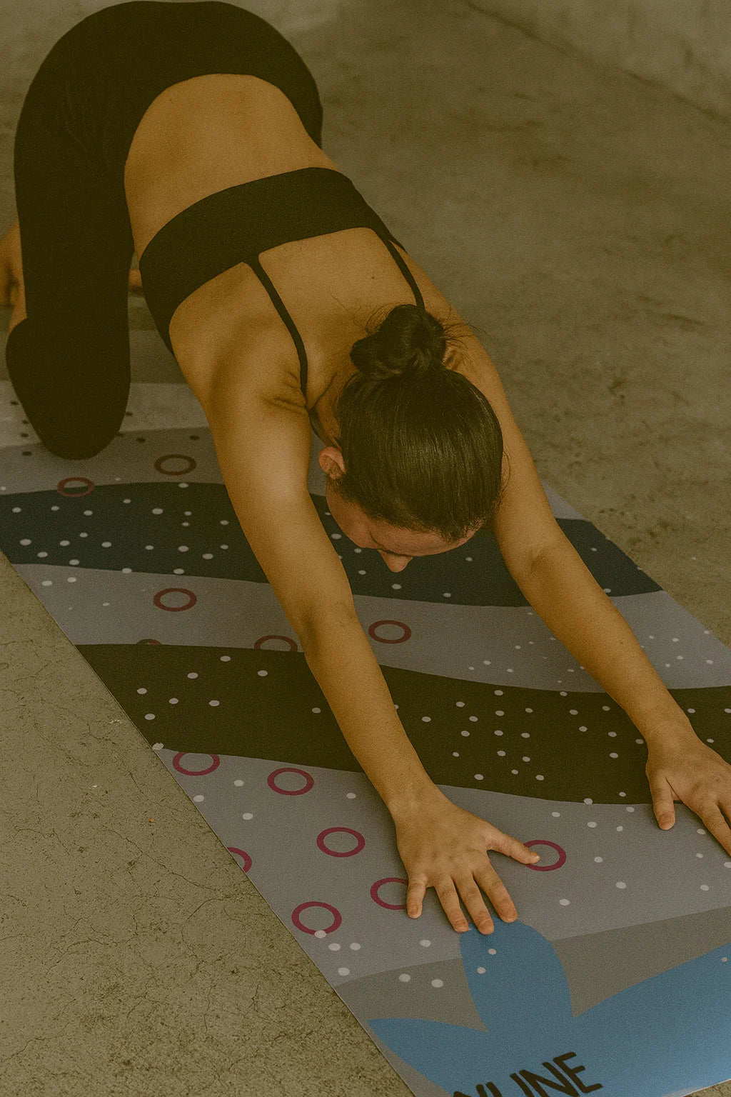 Person practicing yoga on a mat with a patterned design.