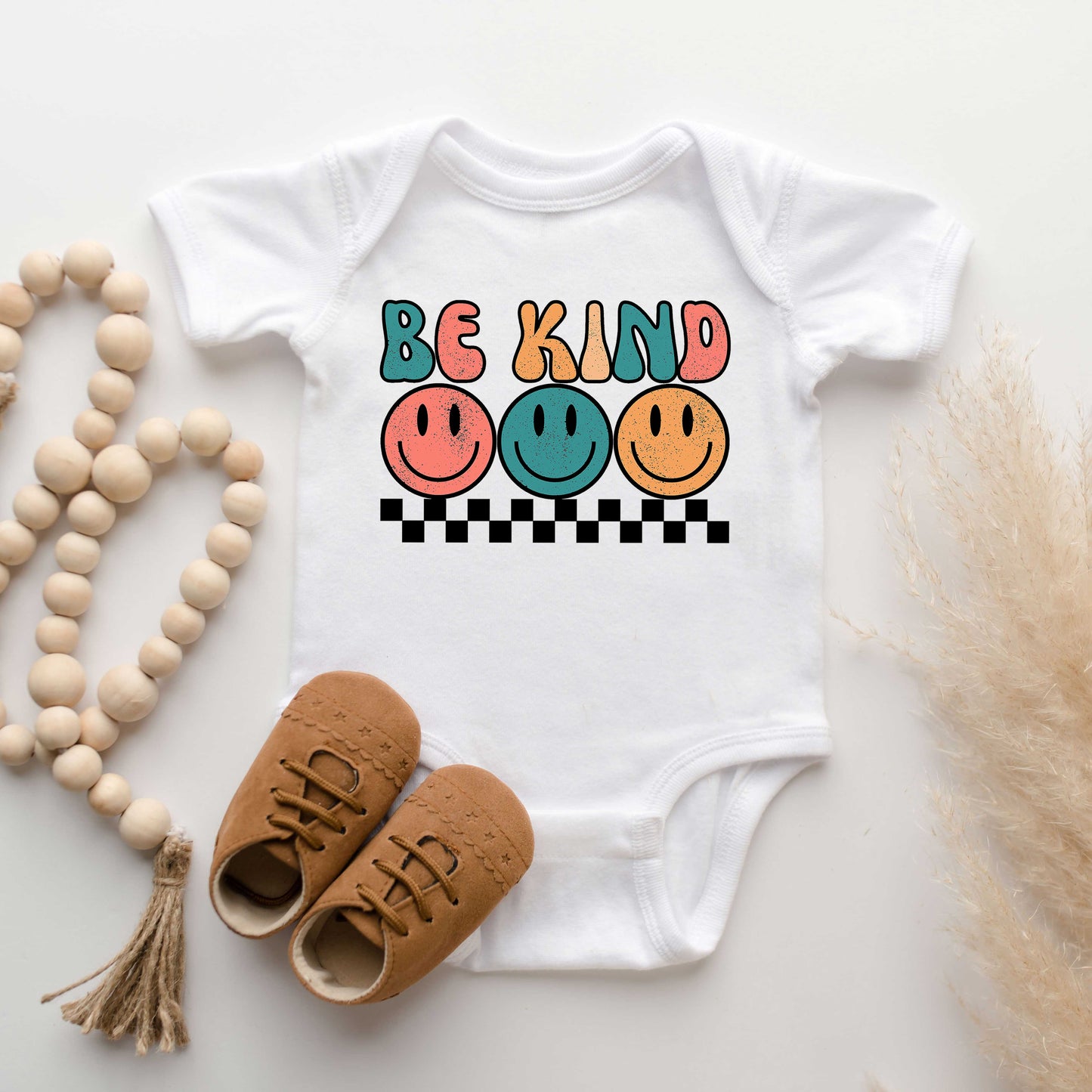 Checkered Be Kind Smiley Face | Baby Graphic Short Sleeve Onesie by The Juniper Shop