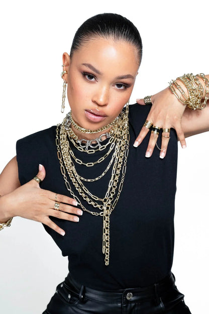 Woman wearing gold jewelry showcasing Dean Lariat Necklace style and elegance