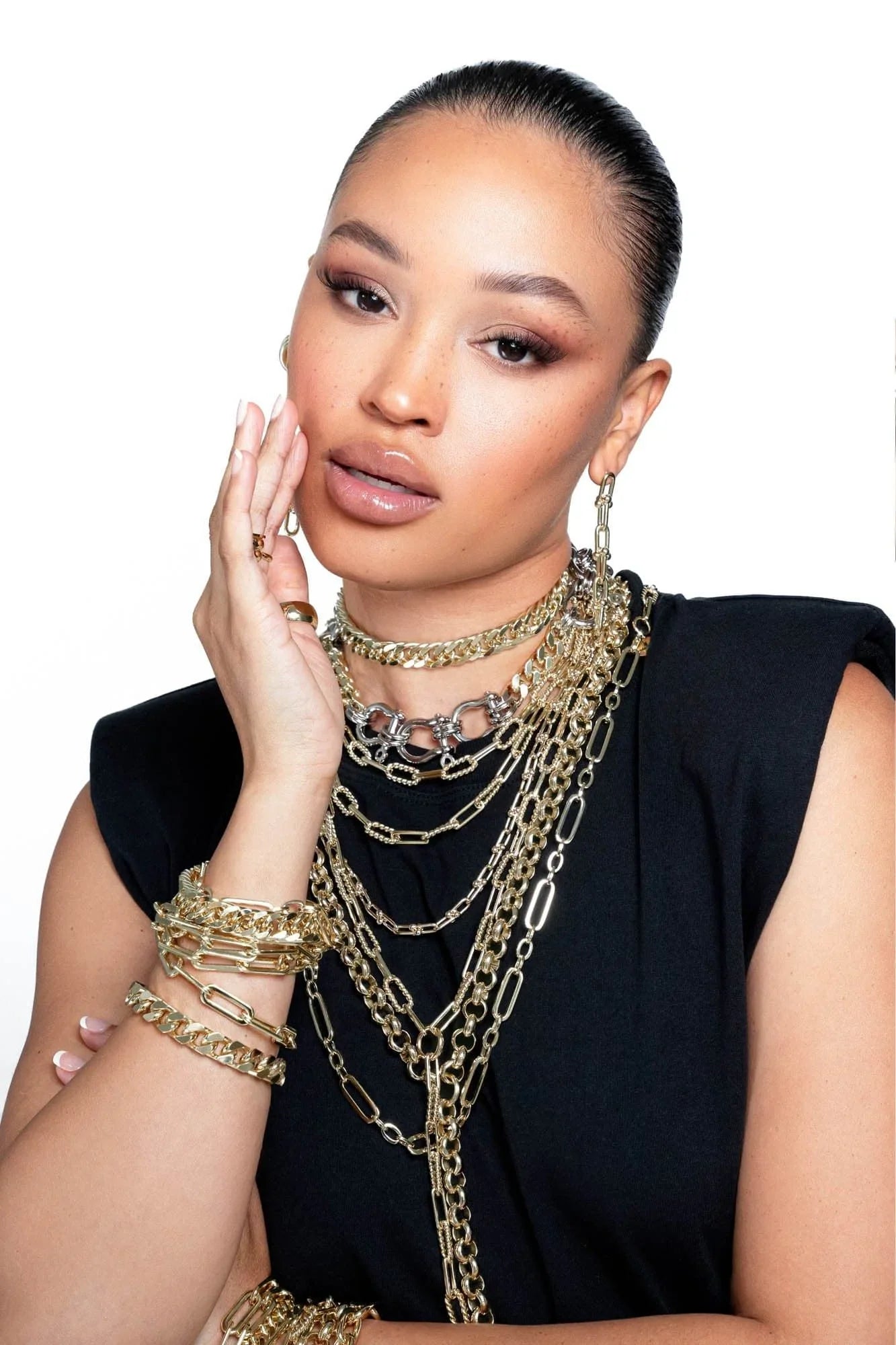 Woman wearing multiple gold chains and bracelets with the Dean Lariat Necklace style