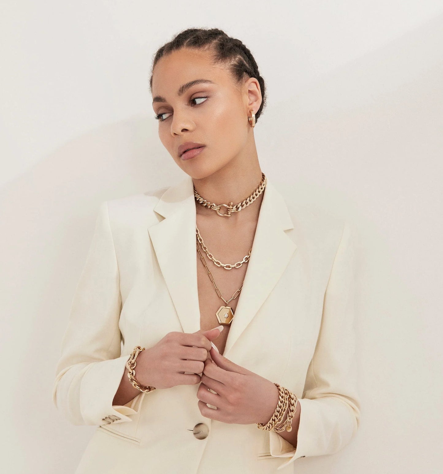 Woman showing off Roxy Bracelet with gold jewelry and a white blazer