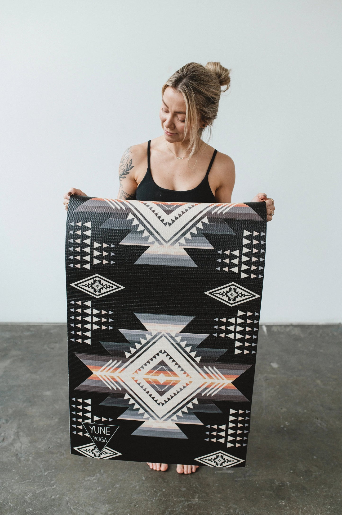 Woman holding a large black and white patterned rug