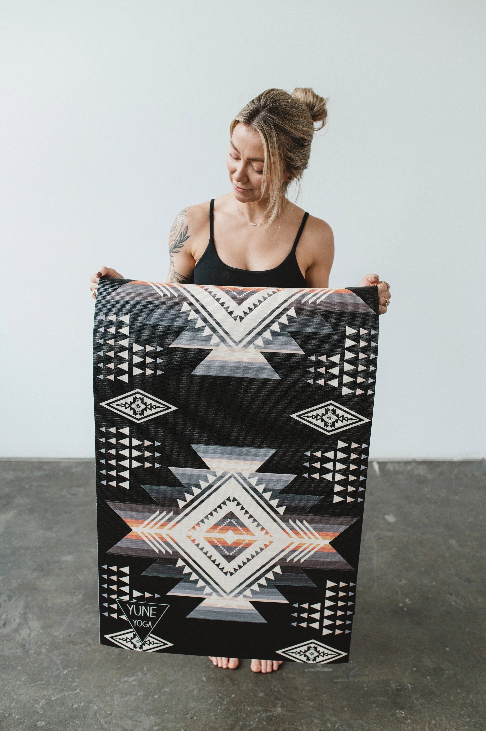 Woman holding a large black and white patterned rug
