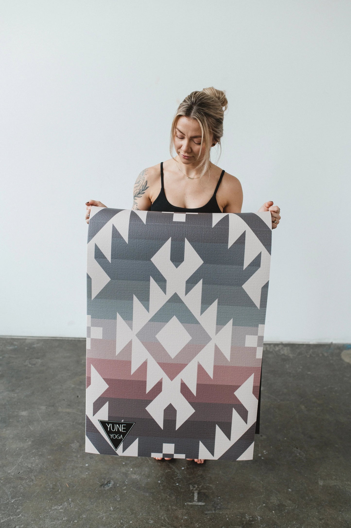 Person holding a large geometric-patterned board against a plain background